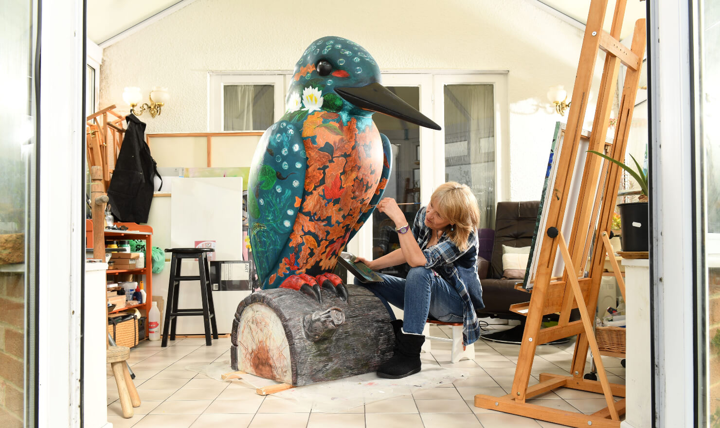 lady painting kingfisher sculpture