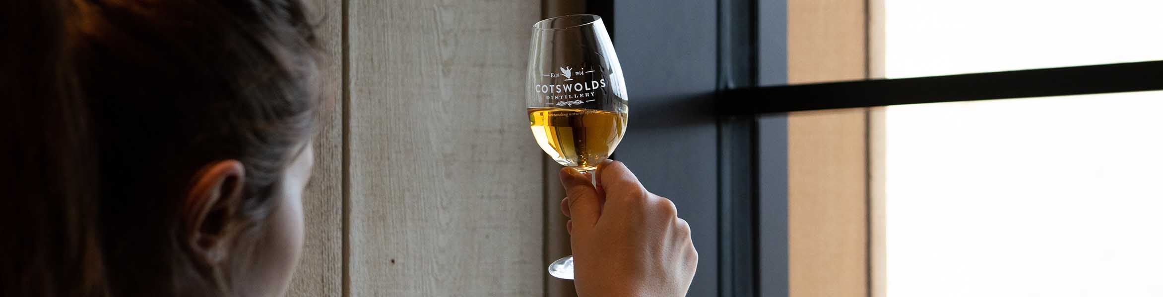 person holding glass of whisky